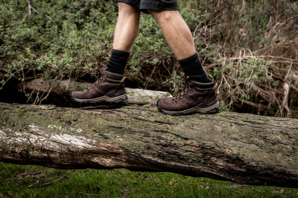 A man walking on a log in hiking boots